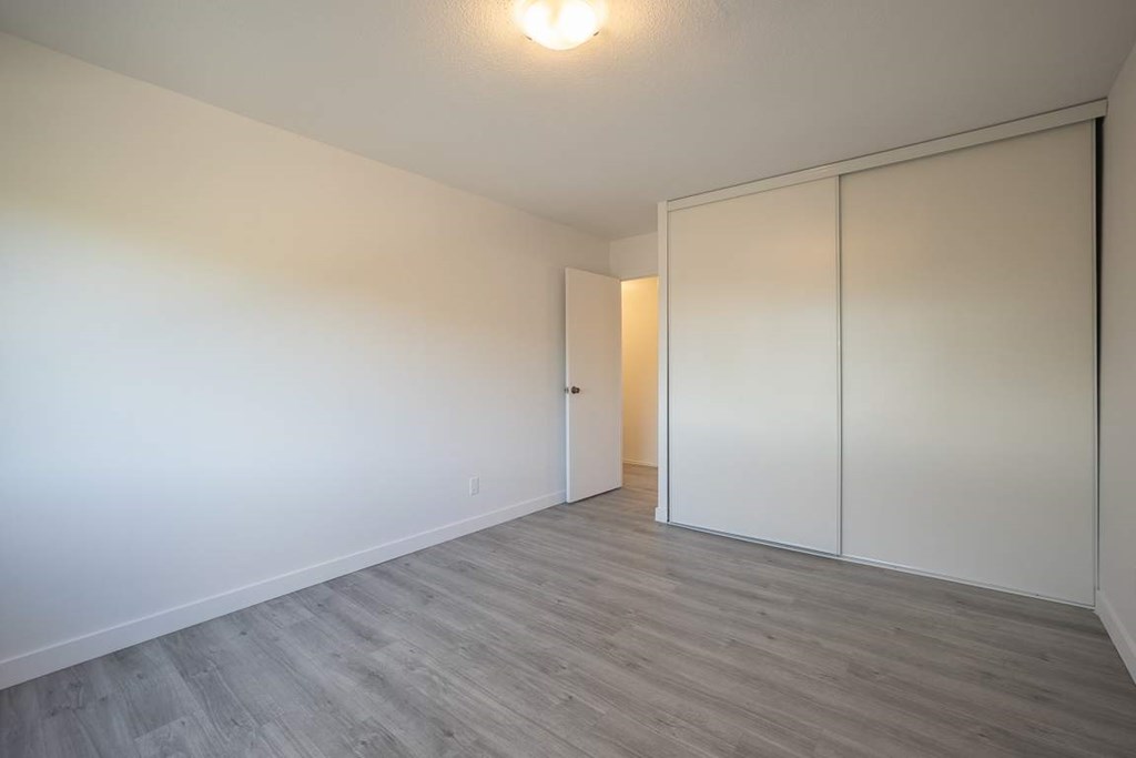 A room with a white door and a grey floor.