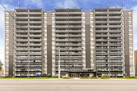 A large, modern apartment building with multiple balconies and a flat roof.