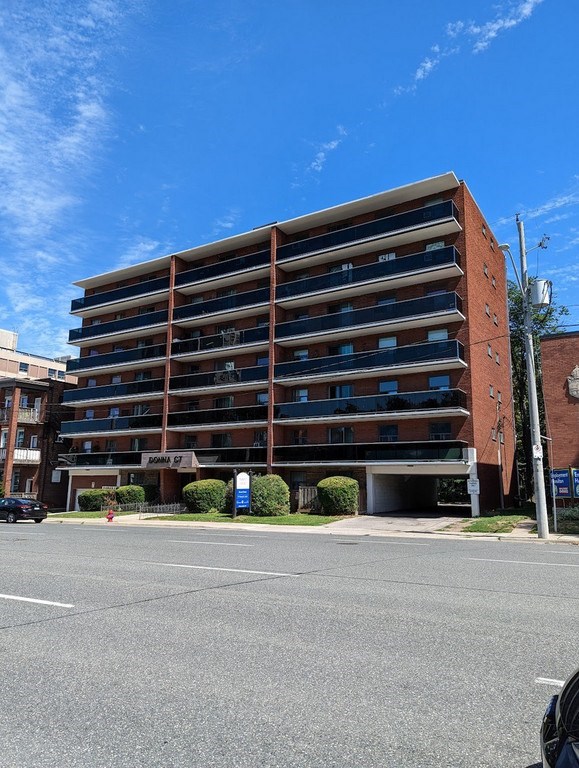 A large red brick building with a parking lot in front.