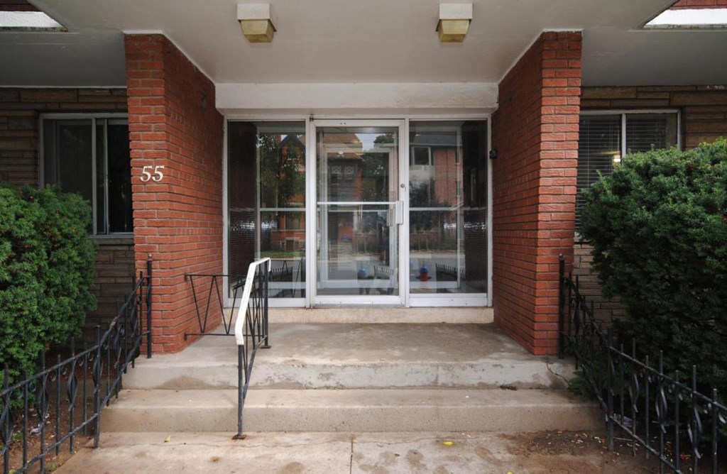 The front door of a building with the number 55 on it.