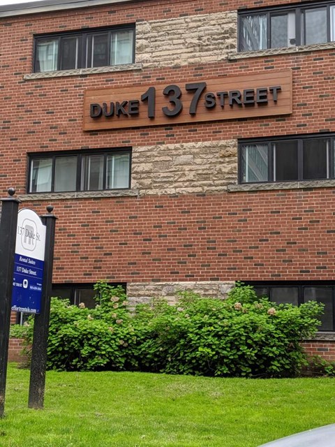A brick building with a sign that says Duke 137 Street.