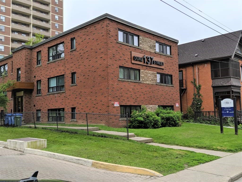 A red brick building with the words "Hillcrest Manor" on the front.