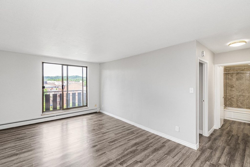 A room with a large window and wooden flooring.