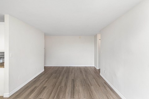 A room with wooden flooring and white walls.