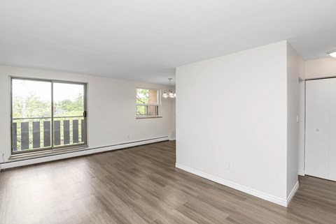 A large empty room with wooden floors and white walls.