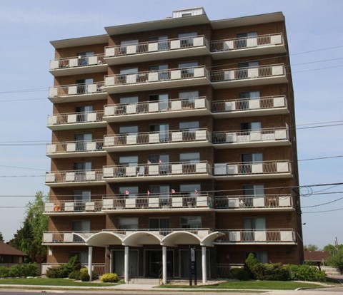 A large apartment building with balconies and a covered entrance.