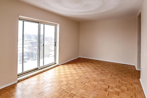 A room with a large window and wooden flooring.