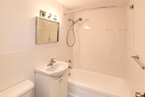 A white bathroom with a toilet, sink, and bathtub.