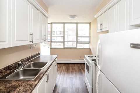 A kitchen with white cabinets and a granite countertop.