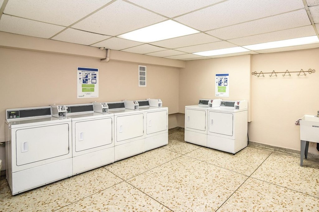 A row of white washing machines in a laundromat.