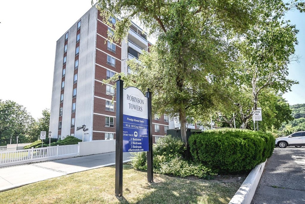 A sign for Robinson Towers stands in front of a brick building.
