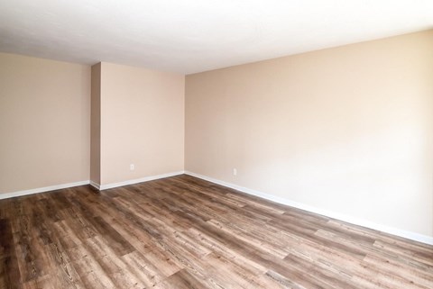 A room with wooden flooring and white walls.