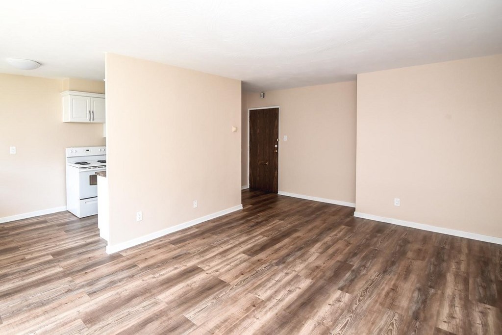 A room with wooden flooring and a white appliance.