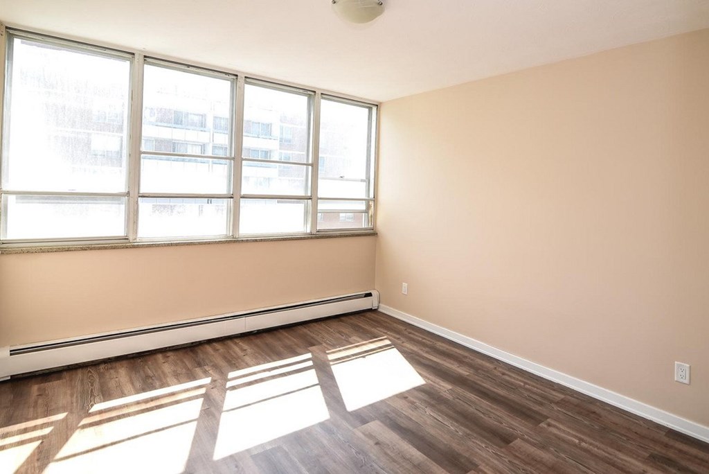 A room with a large window and wooden flooring.
