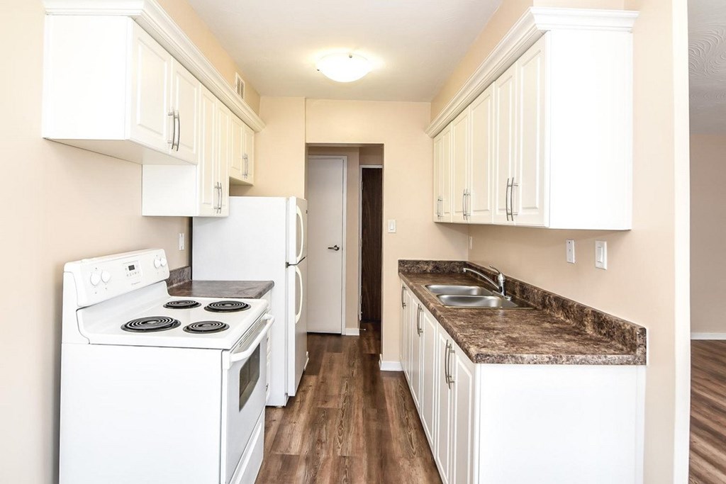 A kitchen with white appliances and cabinets.