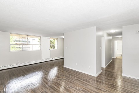 A large empty room with wooden floors and white walls.