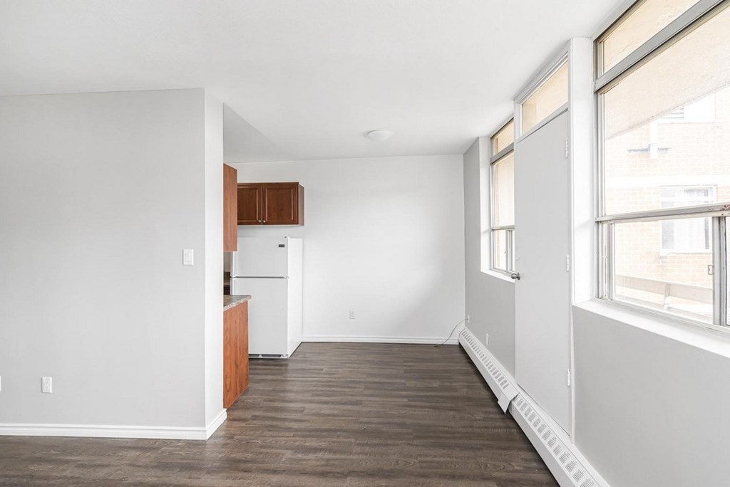 A kitchen with white walls and wooden floors.