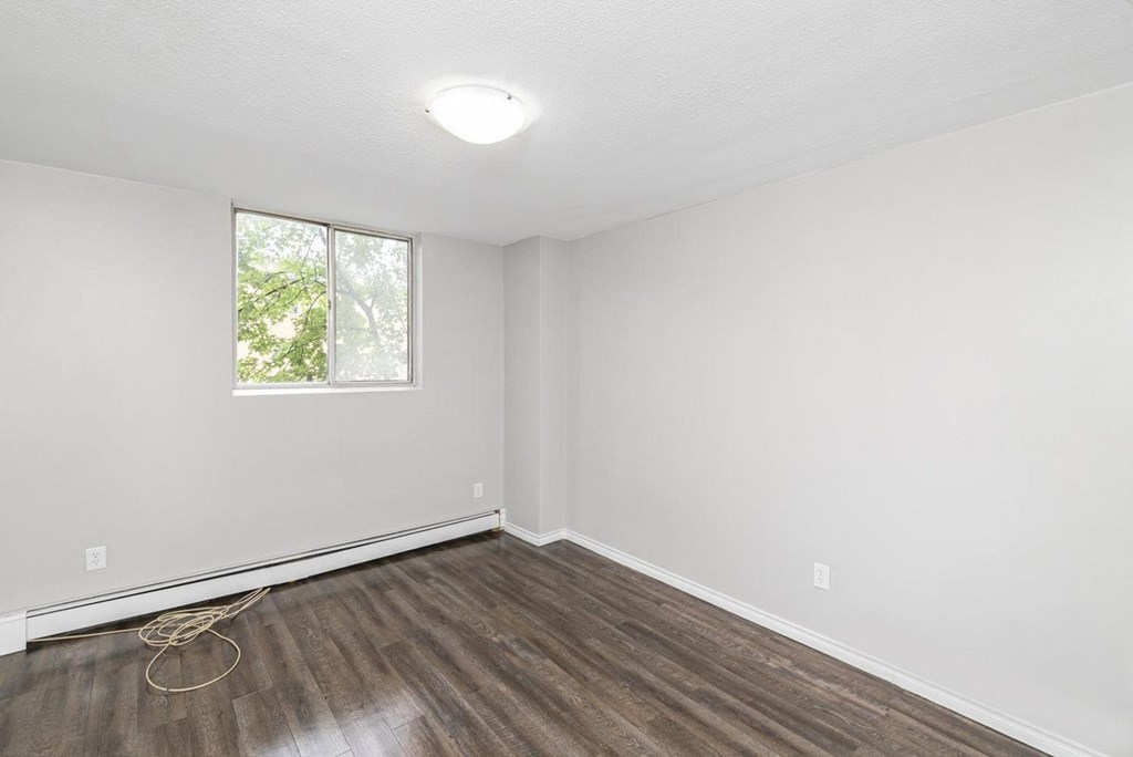 A room with a window and wooden flooring.