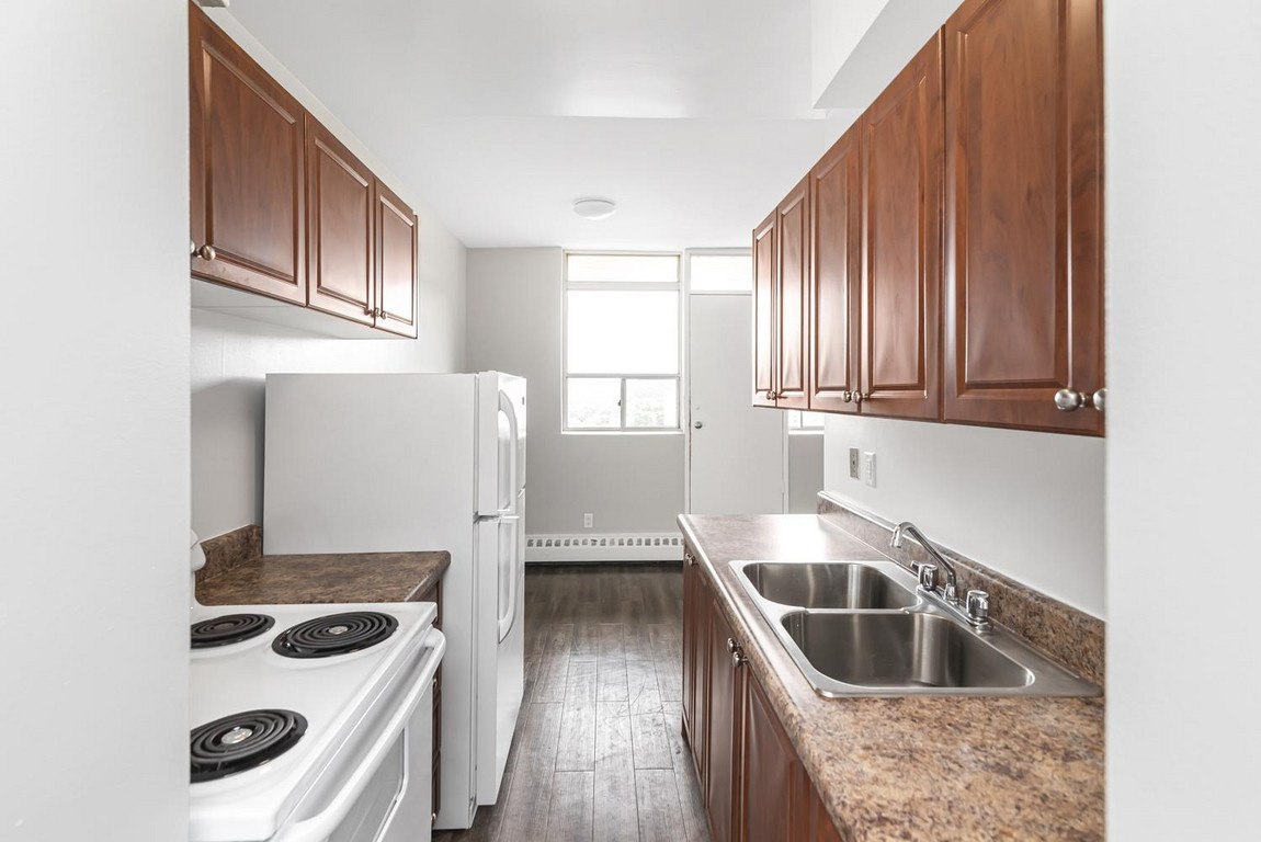 A kitchen with a white stove top oven and a white refrigerator.