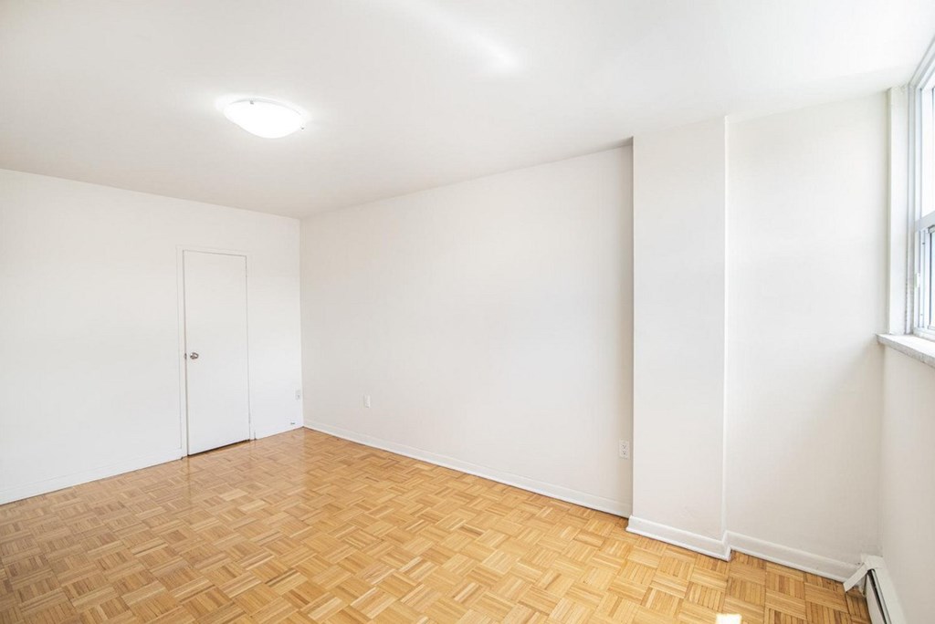 A room with a wooden floor and a white door.