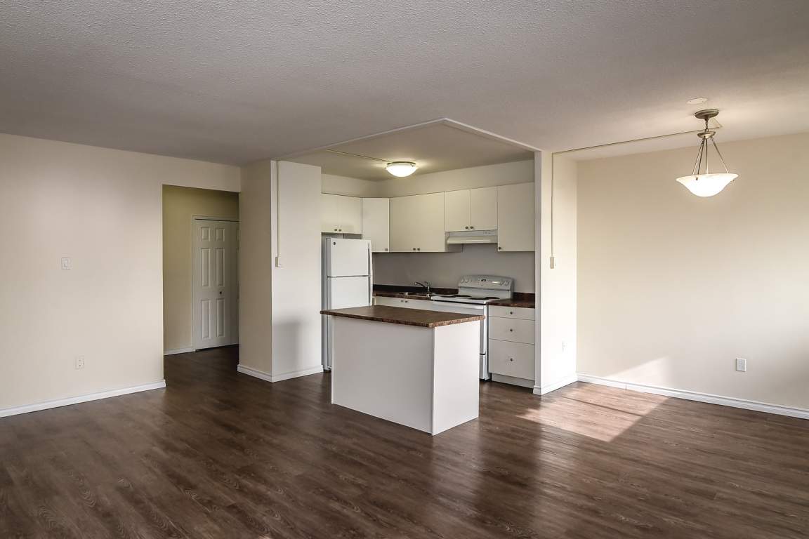 A kitchen with white cabinets and a wooden island.