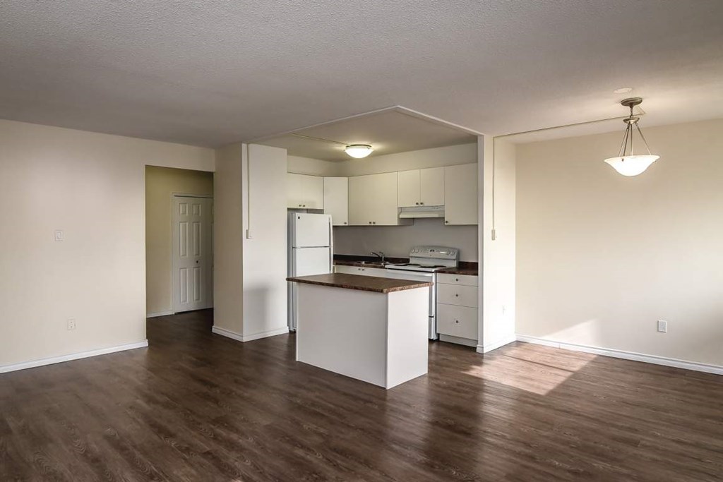 A kitchen with white cabinets and a wooden island.