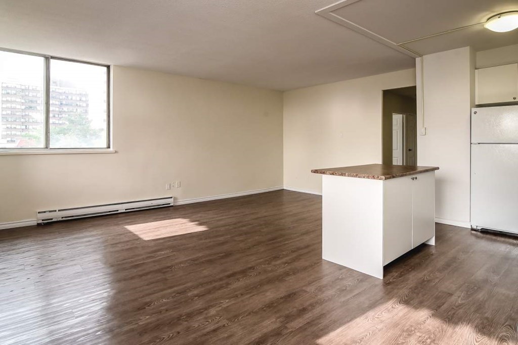 A room with a white cabinet and brown flooring.
