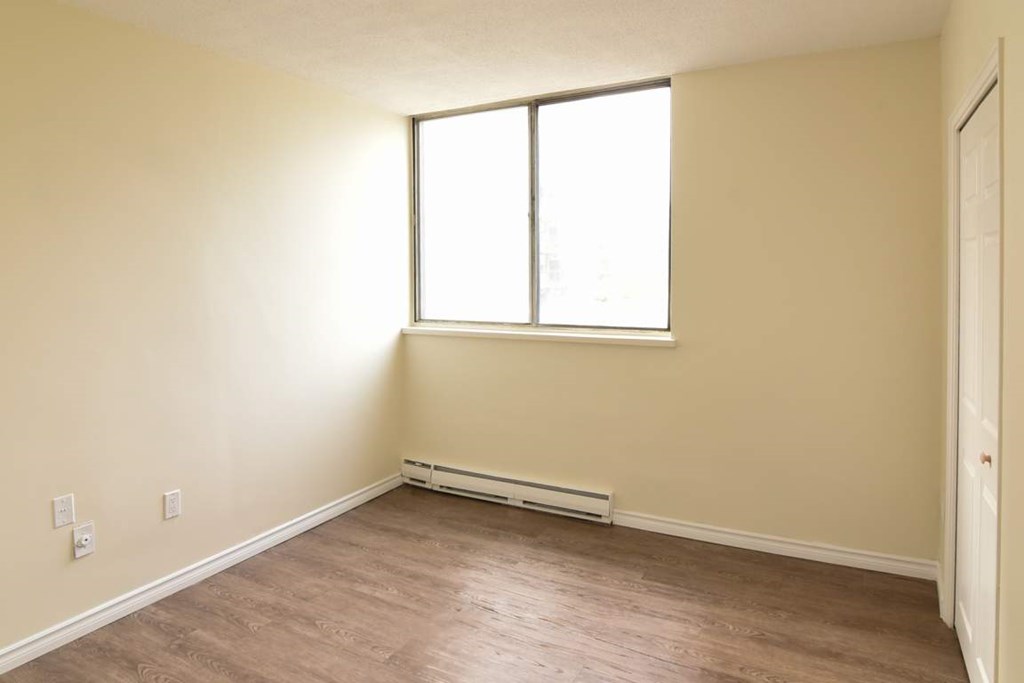 A room with a window and a radiator on the wall.