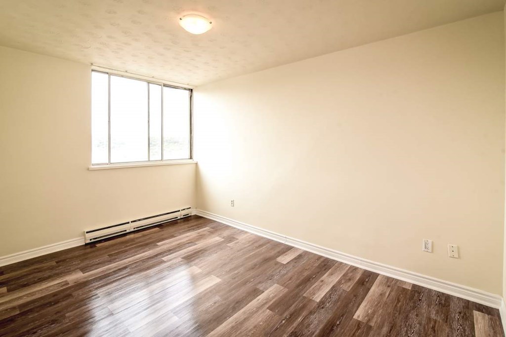 A room with wooden flooring and a window.