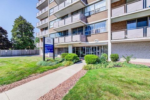 A building with a sign that says "Grace Manor" in front of it.