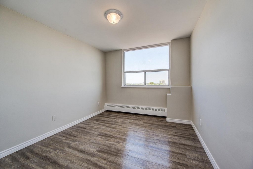 A room with a window and a radiator on the wall.
