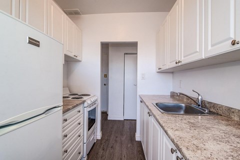 A kitchen with white cabinets and a granite countertop.