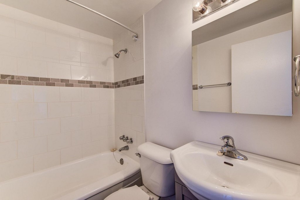 A white bathroom with a tub, toilet, and sink.