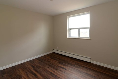 A room with a window and wooden floors.