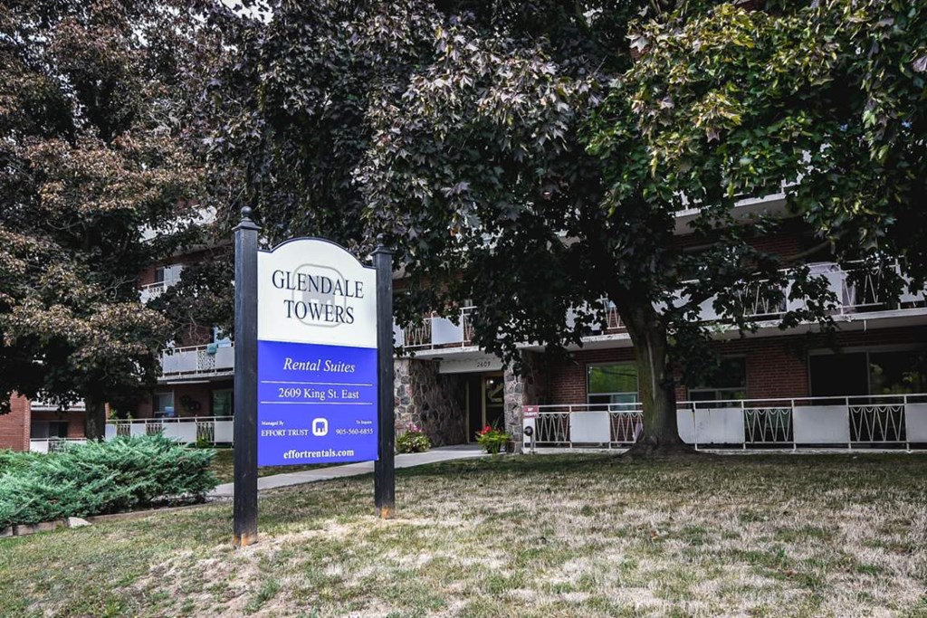 A sign for Glendale Towers stands in front of a building.