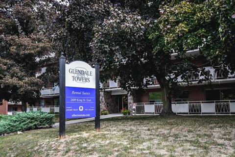 A sign for Glendale Towers stands in front of a building.