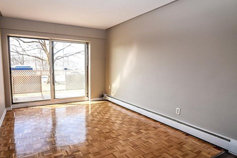 A room with a wooden floor and a sliding glass door.