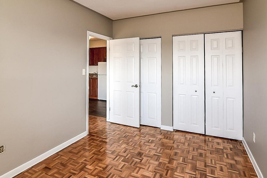 A room with a wooden floor and white doors.