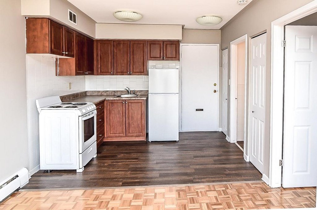 A kitchen with wooden cabinets and a white refrigerator.