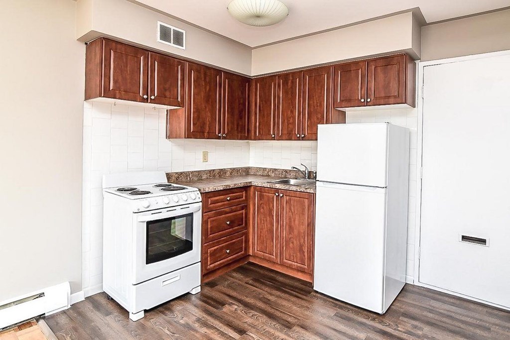 A kitchen with white appliances and wooden cabinets.