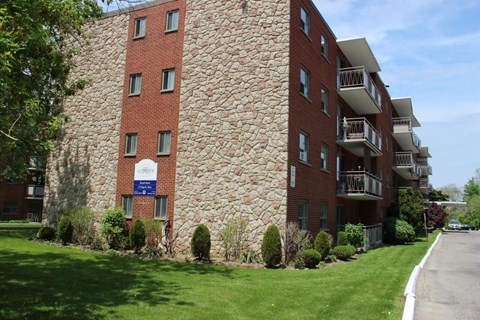 A large red brick building with a balcony on the second floor.