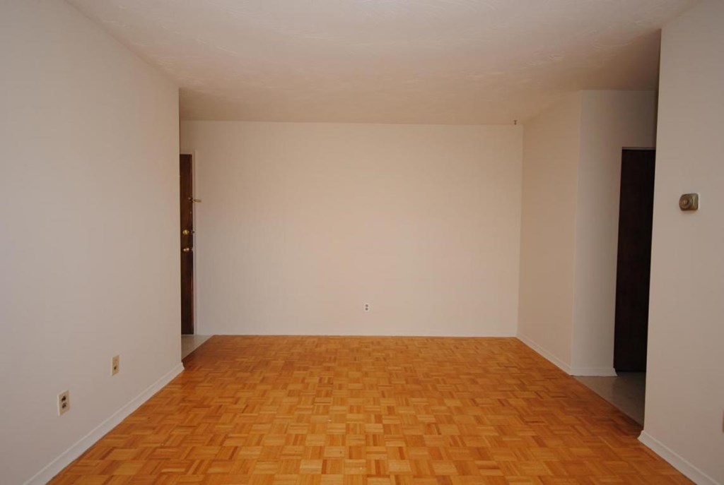Empty room with wooden floor and white walls.