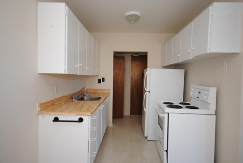 A kitchen with white appliances and cabinets.