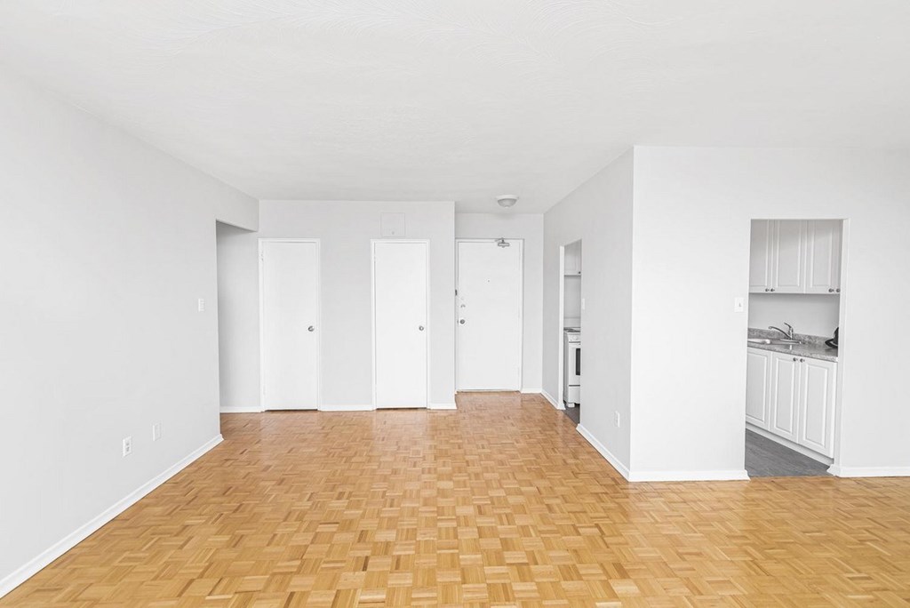 A room with wooden flooring and white walls.