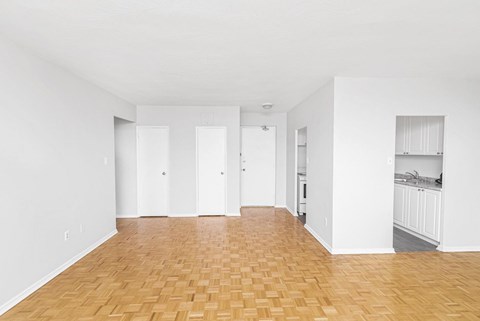 A room with wooden flooring and white walls.