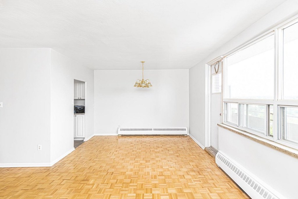 A room with a wooden floor and a chandelier hanging from the ceiling.