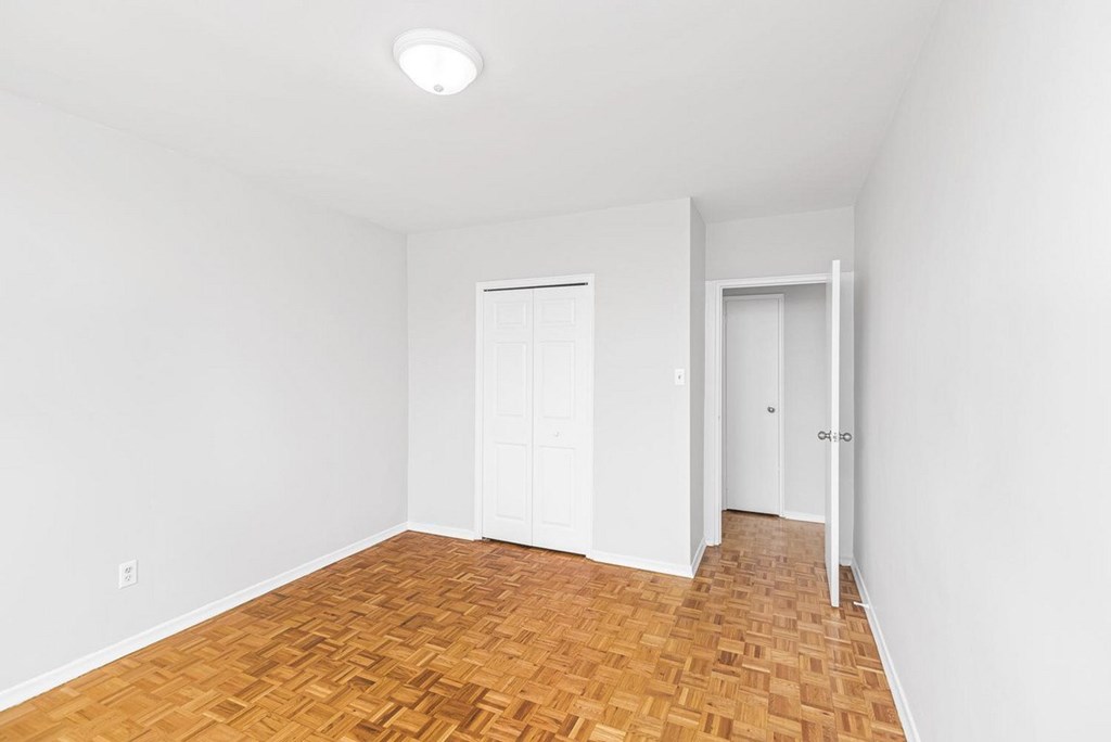 A room with a wooden floor and two white doors.