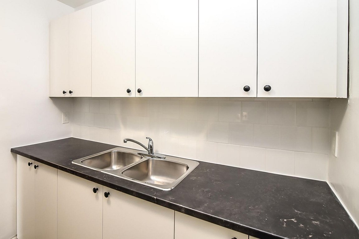 A kitchen with a sink and cabinets.