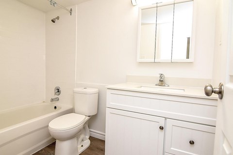 A white bathroom with a toilet, sink, and bathtub.