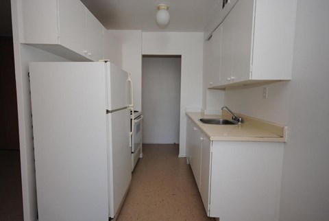 A small kitchen with white appliances and cabinets.